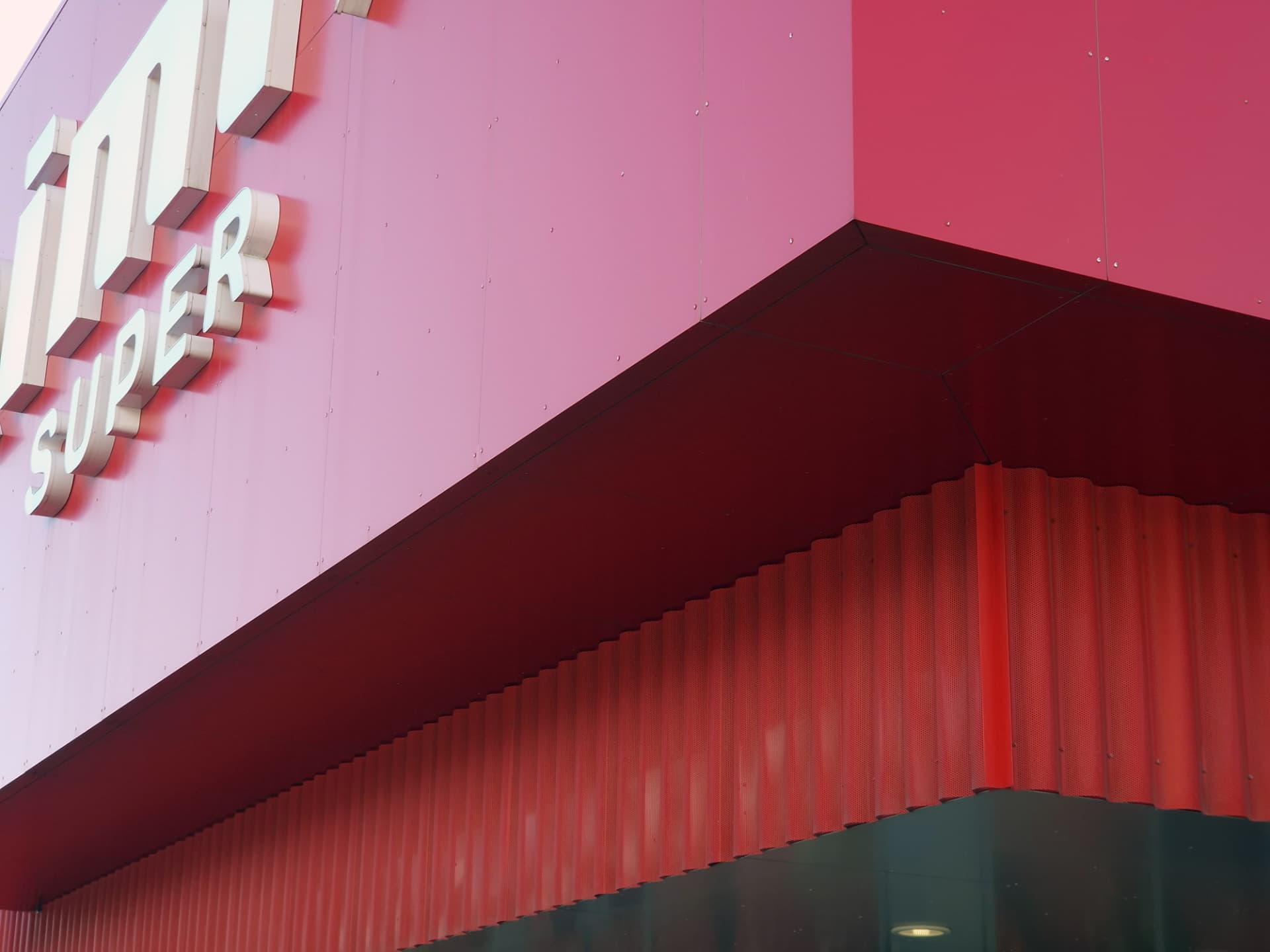Saue Rimi — signage volume and the underside of the perforated metal canopy