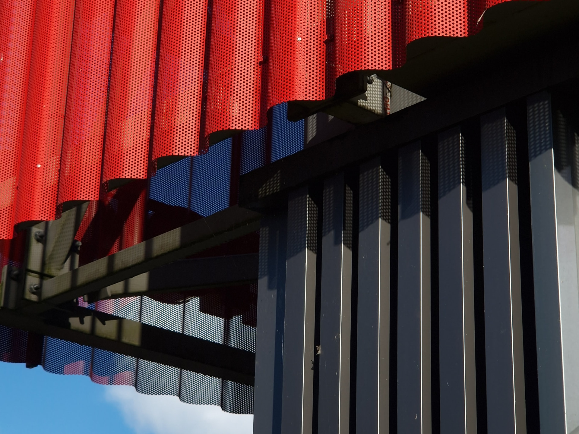 Saue Rimi — close view of perforated metal cladding and the steel support structure
