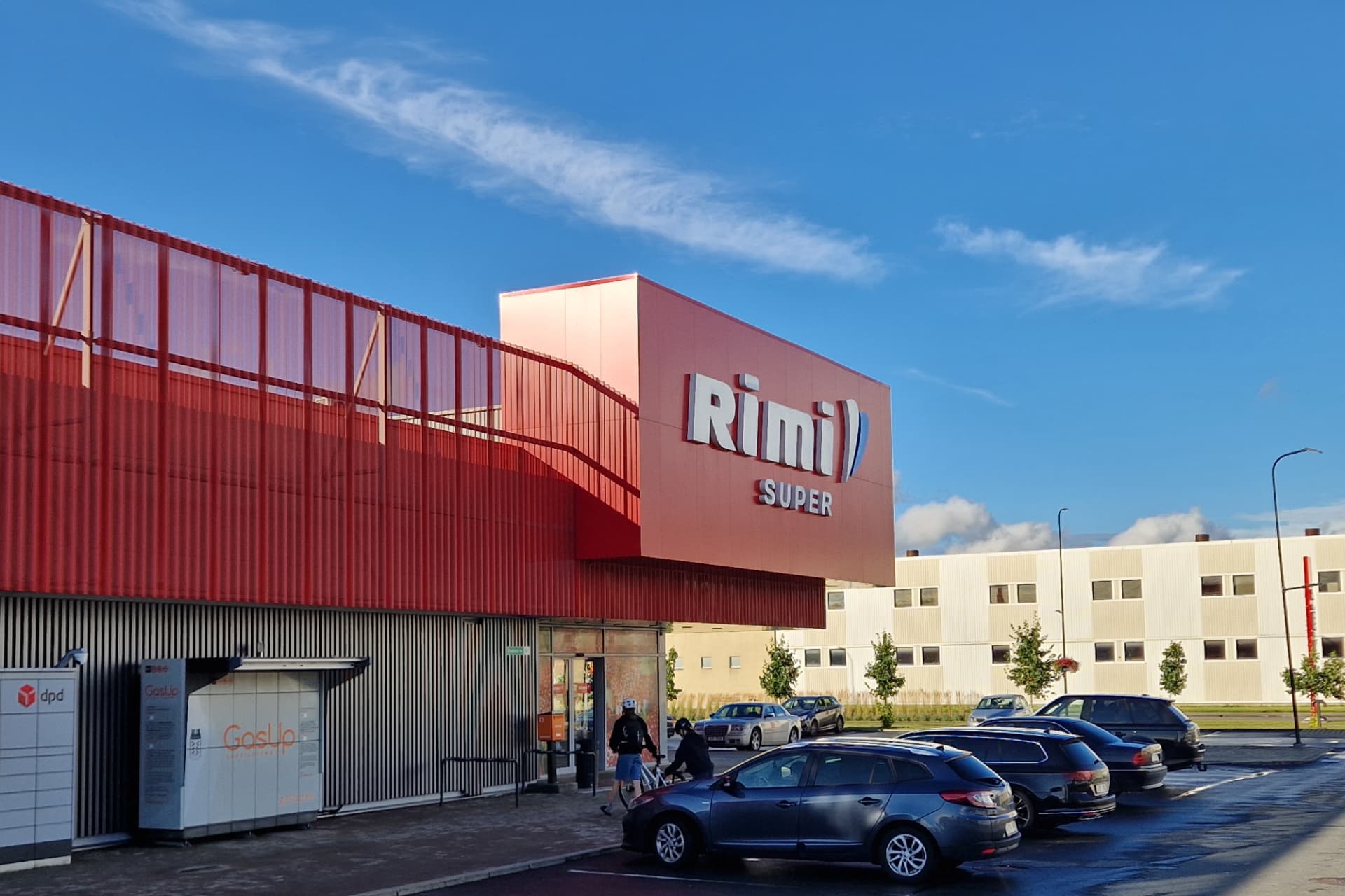 Saue Rimi — entrance volume and forecourt with parcel lockers and parking